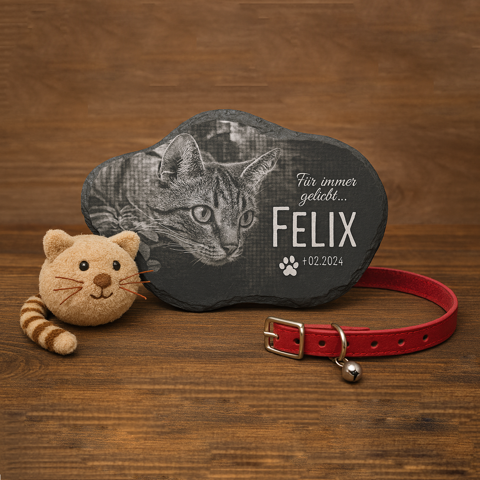 Schieferplatte mit Gravur eines Katzenkopfs, Text 'Für immer geliebt... FELIX +02.2024', daneben rotes Katzenhalsband und Plüschkatze